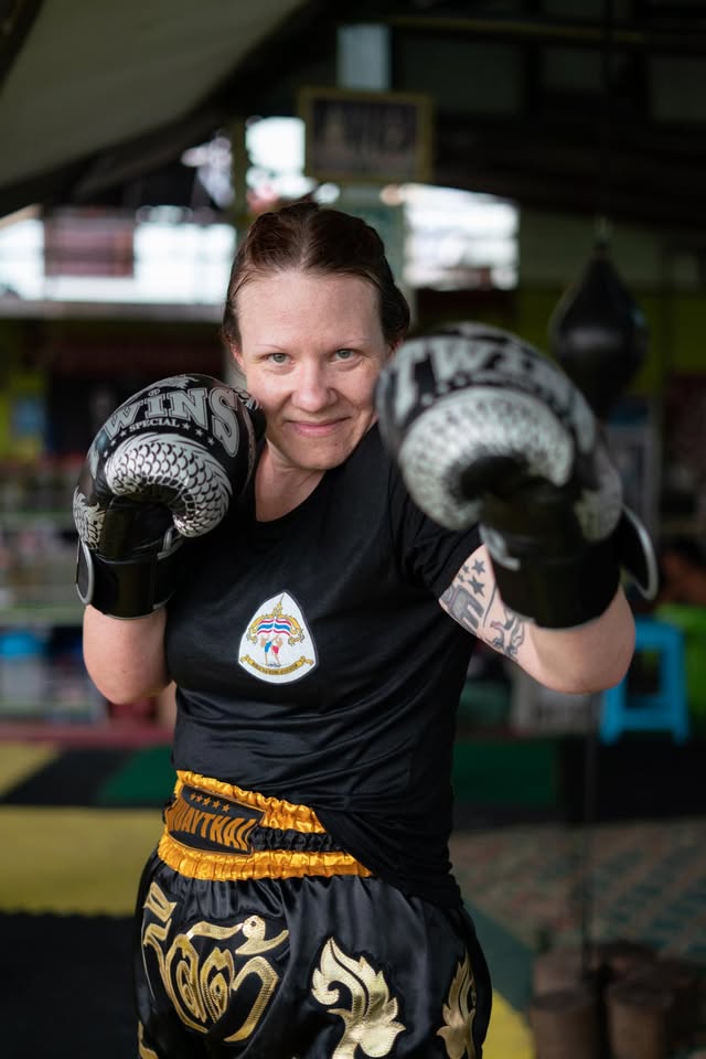 Kru Krysta Scharlach in Muay Thai attire throwing a left jab, full instructor under Ajarn Chai Sirisute.